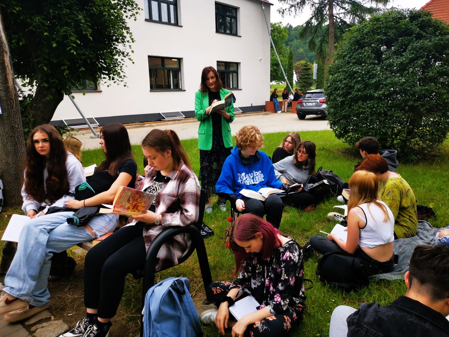 240521 b2. Uczestnicy wraz z wychowawcą czytają