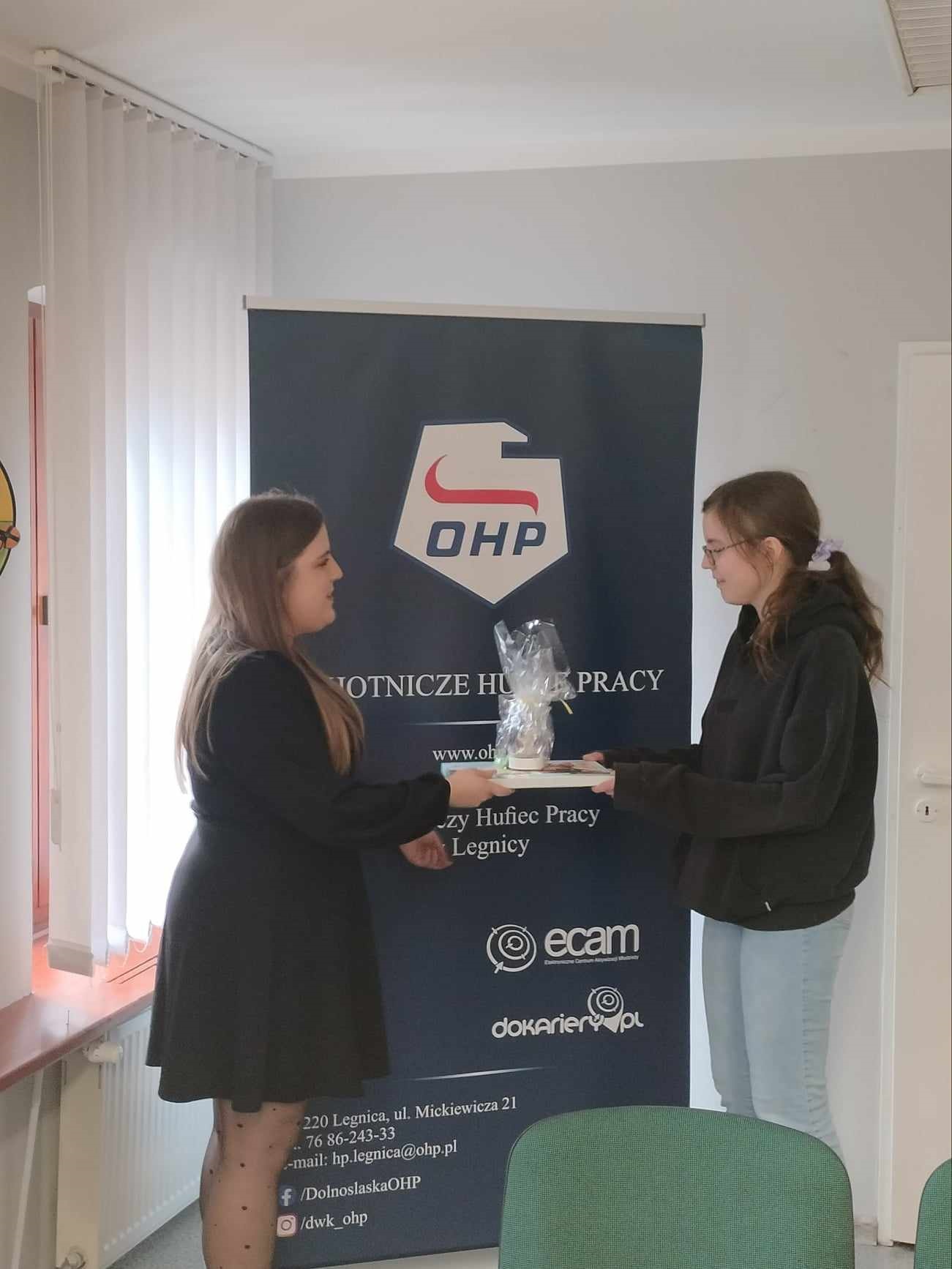 240325 Zdjęcie nr 2 Laureatka odbierająca nagrodę od wychowawcy grupy