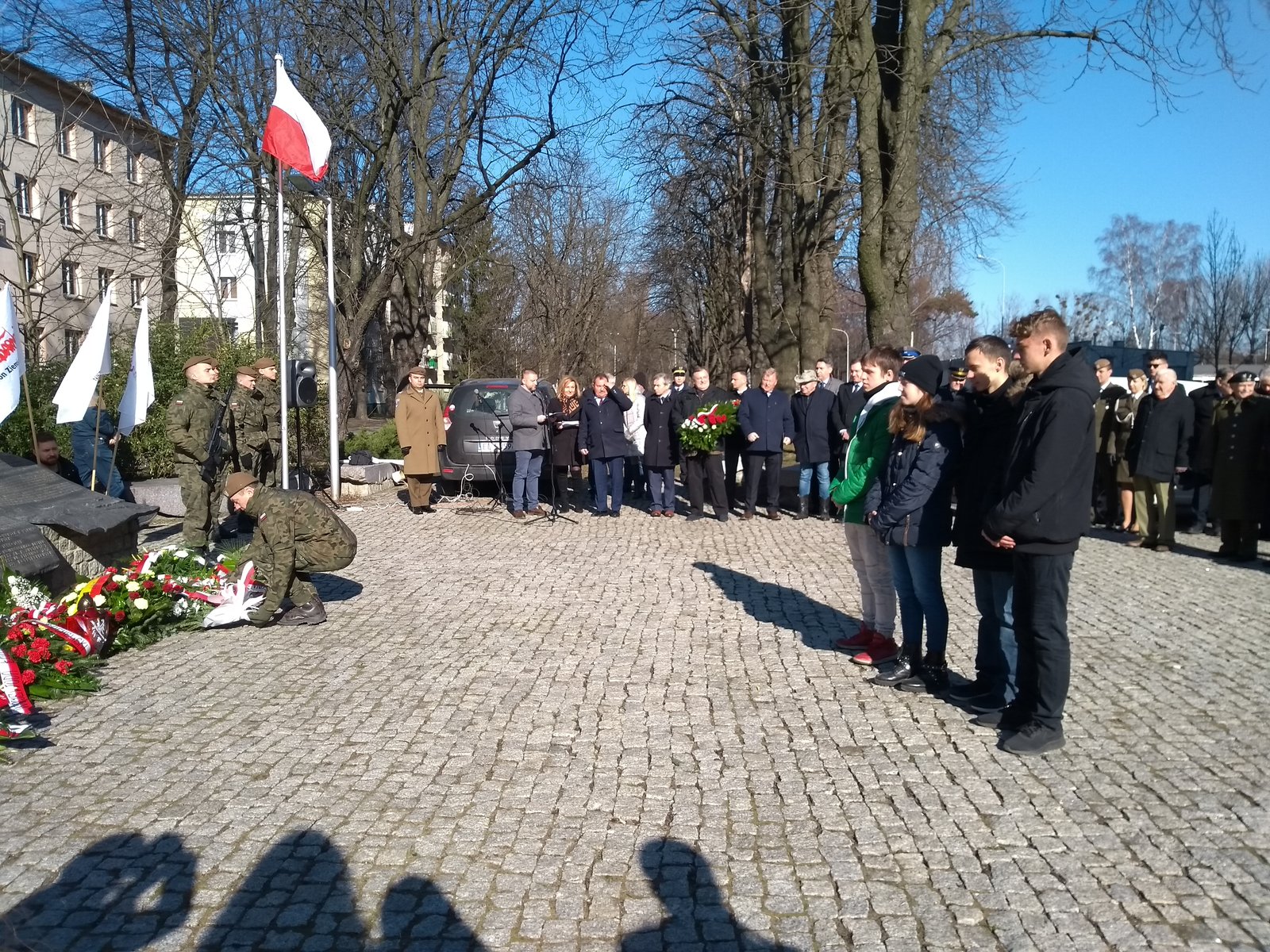 Młodzież składająca kwiaty